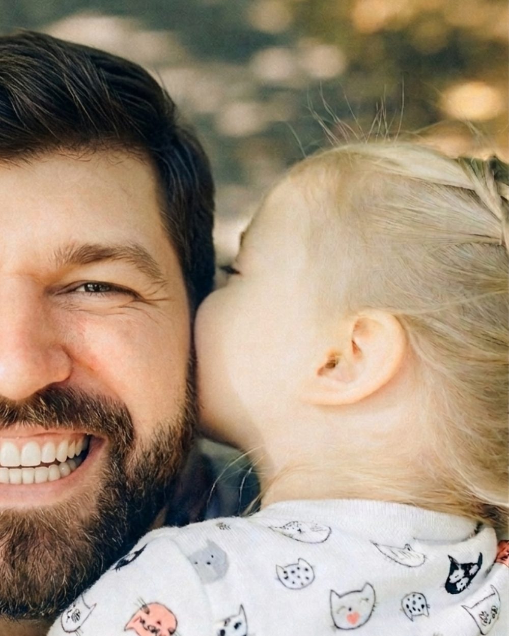 A father embracing his young daughter, a warm candid moment representing the family GuardTies helps protect