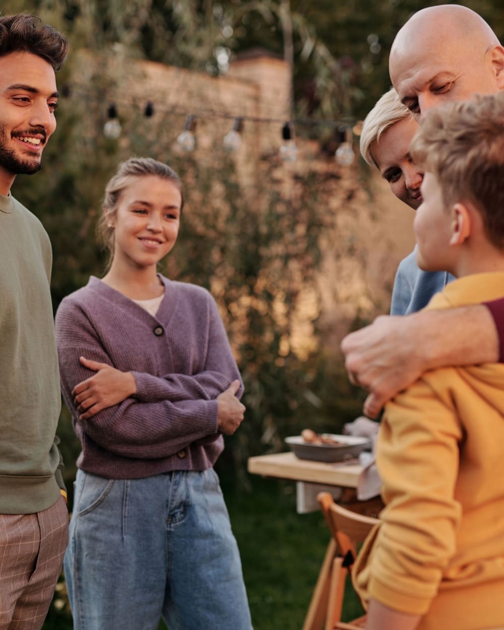 A multi-generational blended family gathered together at an outdoor evening get-together