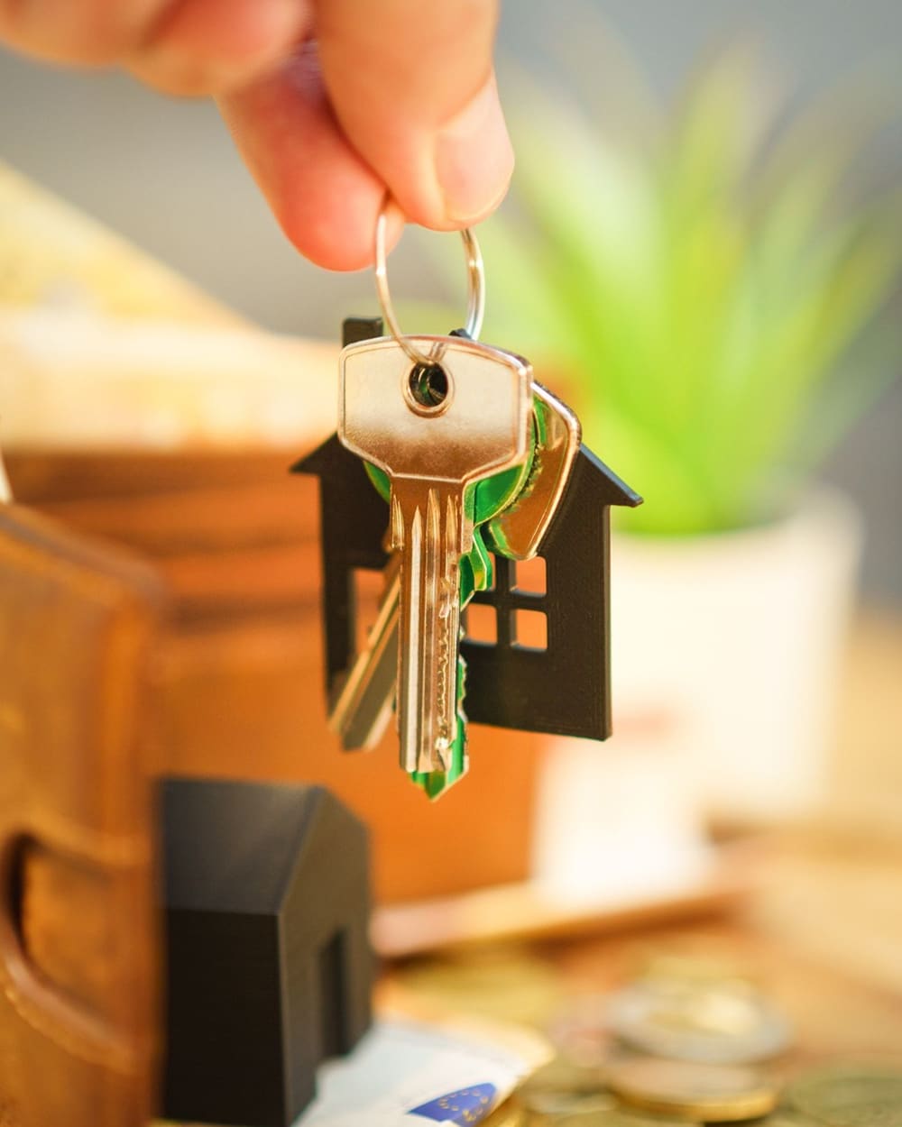 A new homeowner holding a house-shaped keychain with their front door keys