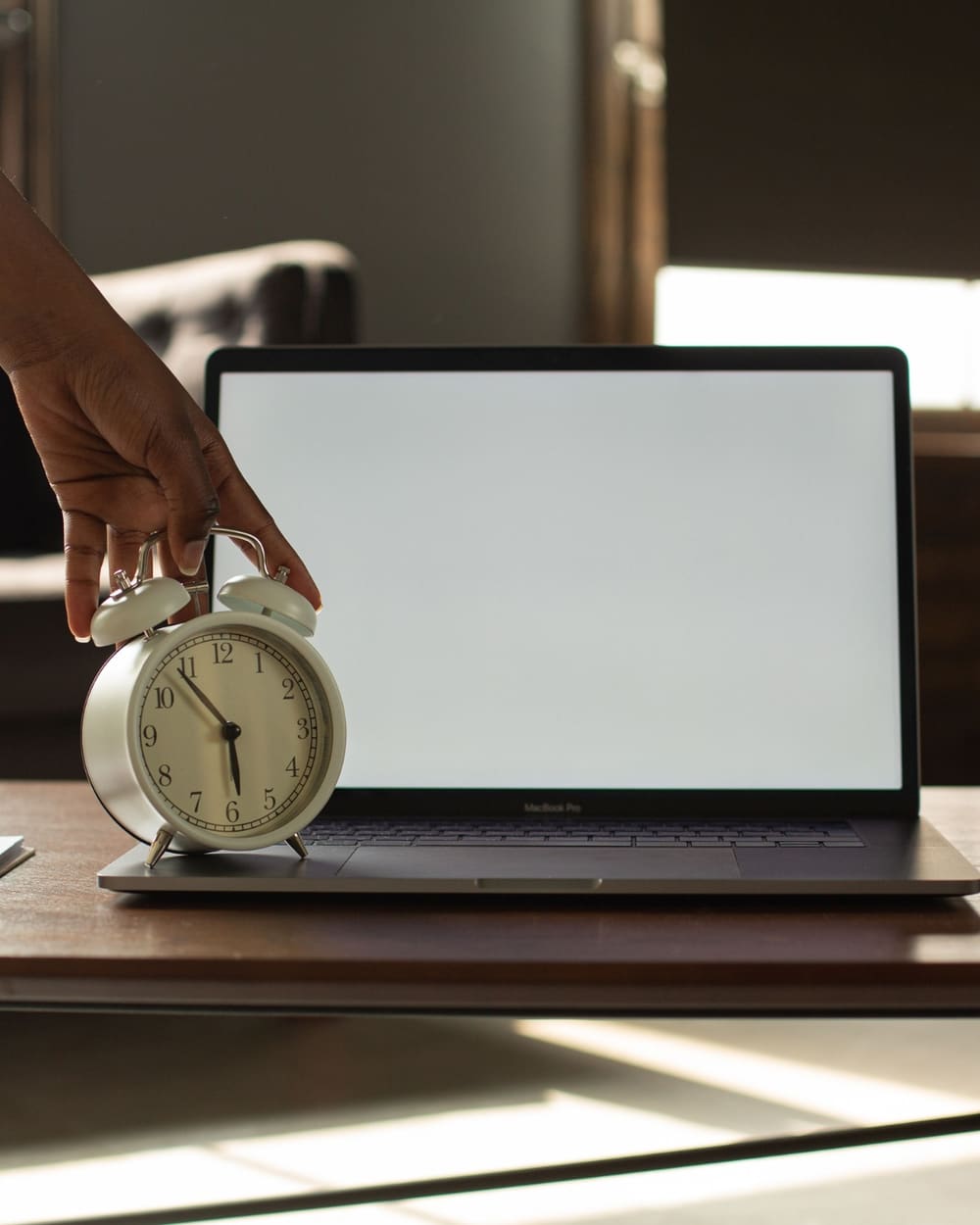 A man relaxed on a couch working on a laptop, putting off a task for later
